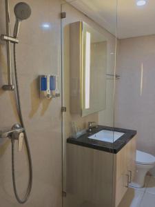 a bathroom with a shower and a sink and a toilet at Channel Stay Warhol Simpang Lima Semarang in Semarang