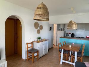 a kitchen and dining room with a table and chairs at Ca la Marta apartamento con piscina y jardín a 150m de la playa in Arenal d'en Castell