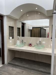 a bathroom with two sinks and a large mirror at Casa Mel, Excelente ubicacion, seguridad in Cozumel