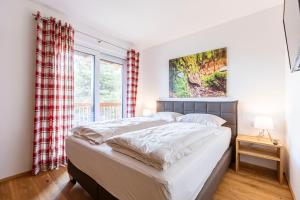 a bedroom with a bed and a window at Turrach Lodges by ALPS RESORTS in Turracher Hohe