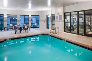 a pool with a dining area and a table and chairs at Courtyard Suffolk Chesapeake in Suffolk