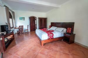- une chambre avec un lit, une table et des chaises dans l'établissement Dzawani Ubud, à Tampaksiring