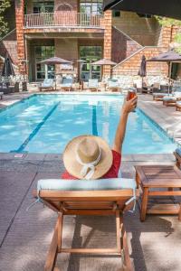 a person sitting in a chair in front of a swimming pool at PlumpJack Inn in Olympic Valley