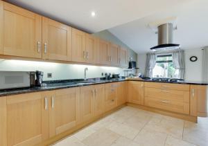 a kitchen with wooden cabinets and a microwave at Home Croft in Tenby