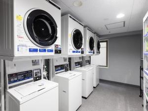 a laundry room with four washers and dryers at KOKO HOTEL Shizuoka in Shizuoka