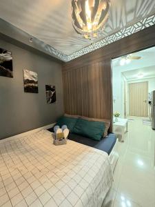 a bedroom with a bed and a chandelier at Fully equipped 1BR Condo at Shore2 near to MOA in Manila