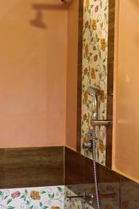 a shower in a bathroom with a faucet at Atulya Kanchi Camp Bandhavgarh in Tāla