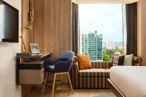 新加坡JEN Singapore Tanglin by Shangri-La的酒店客房设有床、沙发和窗户。