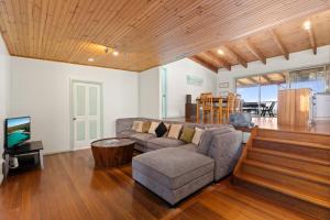a living room with a couch and a tv at Absolute Blue by Experience Jervis Bay in Hyams Beach