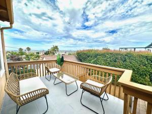 a patio with chairs and a table on a balcony at Entire 5BR Home Hot Tub-Firepit-Patio-Grill in San Diego