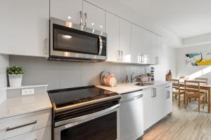 a kitchen with a microwave and a stove top oven at University of Washington New Apartment Studio w/kitchen and balcony in Seattle