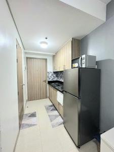 a kitchen with a stainless steel refrigerator and cabinets at Fully equipped 1BR Condo at Shore2 near to MOA in Manila