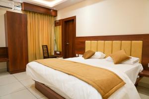 a bedroom with a large bed with a wooden headboard at Sri Krishna Inn - Kempegowda Airport Bangalore in Bangalore