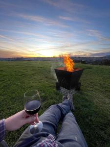 une personne allongée sur l'herbe avec un verre de vin dans l'établissement Widdo's Place, à Tumbarumba