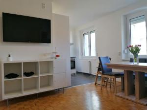 uma sala de estar com uma mesa e uma televisão na parede em Wundervolle Familienwohnung nahe Schönbrunn em Viena