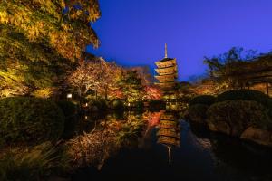 a view of a garden at night with a tower at OMO3 Kyoto Toji by Hoshino Resorts in Kyoto