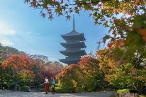 two people standing in front of a pagoda at OMO3 Kyoto Toji by Hoshino Resorts in Kyoto