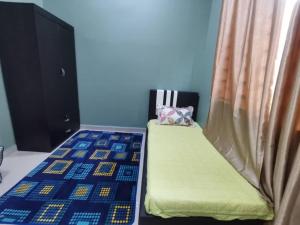 una camera da letto con letto con materasso verde e tenda di Sunshine Homestay a Kuala Terengganu