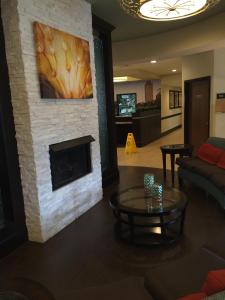 a living room with a fireplace with a painting on the wall at Club Hotel Nashville Inn & Suites in Nashville