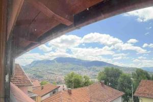 una ventana con vistas a una montaña en Stan sa pogledom na grad, en Sarajevo
