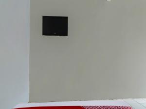 een witte muur met een flatscreen-tv bij OYO 90809 Homestay Black Pink Merah Jambu Syariah in Garut