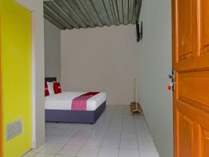 een kleine slaapkamer met een bed en een raam bij OYO 90809 Homestay Black Pink Merah Jambu Syariah in Garut