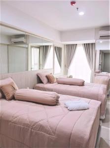a room with four beds with pillows on them at Channel Stay Warhol Simpang Lima Semarang in Semarang