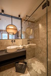 a bathroom with a sink and a shower at All In Resort Schwarzbrunn - 4 Sterne Superior in Stans