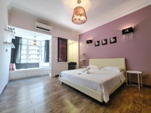 a bedroom with a white bed and a pink wall at GurneyVille in George Town