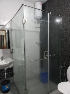 a glass shower in a bathroom with a sink at Sunshine Beach Villa - Kuzhuppilly in Cherai Beach +25 photos