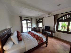 - une chambre avec un grand lit et 2 fenêtres dans l'établissement Dzawani Ubud, à Tampaksiring
