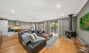 a living room with a couch and a fireplace at Lilies on Lovedale Estate - Heated Pool and Spa in Lovedale