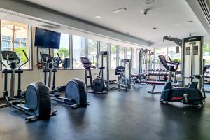 a gym with a bunch of treadmills and machines at ALH Vacay - 2 bedrooms Apartment in Golf Towers 1 in Dubai