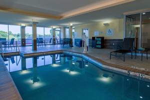 - une piscine avec des chaises et des tables dans un bâtiment dans l'établissement Fairfield Inn & Suites Duncan, à Duncan