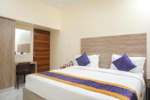 - une chambre avec un grand lit et des oreillers bleus dans l'établissement Redstone Service Apartment-TNagar Near USConsulate, à Chennai