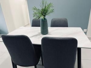 a table with chairs and a vase with a plant on it at Majestic maxim 3 bedrooms link MRT cheras Kuala lumpur in Cheras