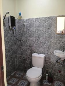 a bathroom with a toilet and a sink at Bluewaves Apartment in Dauis