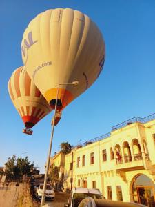 um balão de ar quente num poste em frente a um edifício em Alice in Cappadocia em Üçhisar