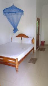 a bedroom with a bed with a blue umbrella on it at Pranu House in Nilaveli