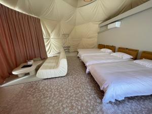 two beds in a room with a tent at ポセイドン グランピング Poseidon Glamping in Kujukuri