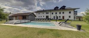 ein großes Haus mit einem Swimmingpool im Hof in der Unterkunft Landurlaub Eichinger inklusive AktivCard! E-Ladesäule! Ganz Jahres beheizter Salzwasserpool in Thurmansbang