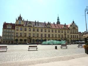 a large building with benches in front of it at Golden Apartments Wrocław&Uniwersytecka in Wrocław