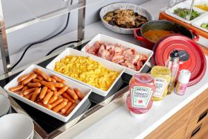 a kitchen counter with three trays of food on it at Travelodge Nagoya Sakae in Nagoya