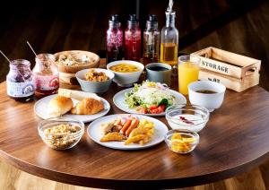 una mesa de madera con platos de comida. en Travelodge Nagoya Sakae, en Nagoya