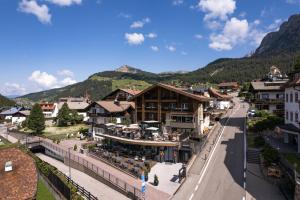 a view of a town with mountains in the background at Hotel Sun Valley in Selva di Val Gardena