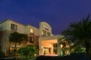 a hotel at night with palm trees in front of it at SpringHill Suites St Petersburg Clearwater in Clearwater