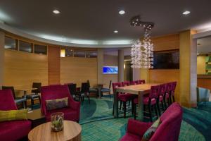 a restaurant with purple chairs and tables and a chandelier at SpringHill Suites St Petersburg Clearwater in Clearwater