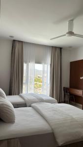 ein Hotelzimmer mit 4 Betten und einem Fenster in der Unterkunft بيوت الخزام in Salmah