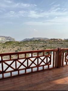 eine Holzterrasse mit Blick auf die Wüste in der Unterkunft بيوت الخزام in Salmah