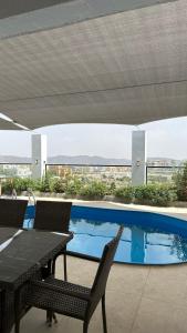 a patio with a table and chairs and a swimming pool at بيوت الخزام in Salmah